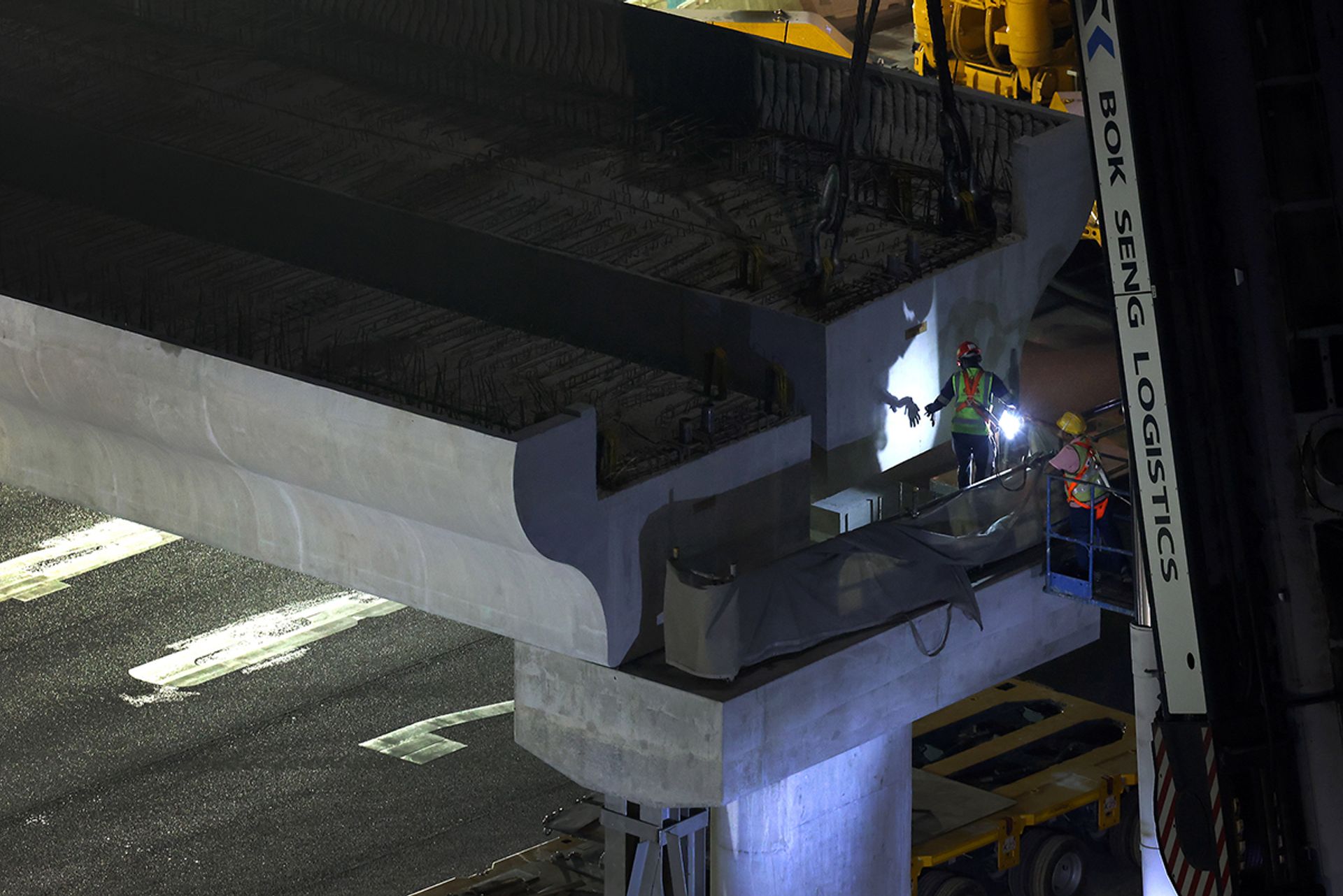 Workers checking on the alignment of the beam as it is being installed over the PIE on March 23.