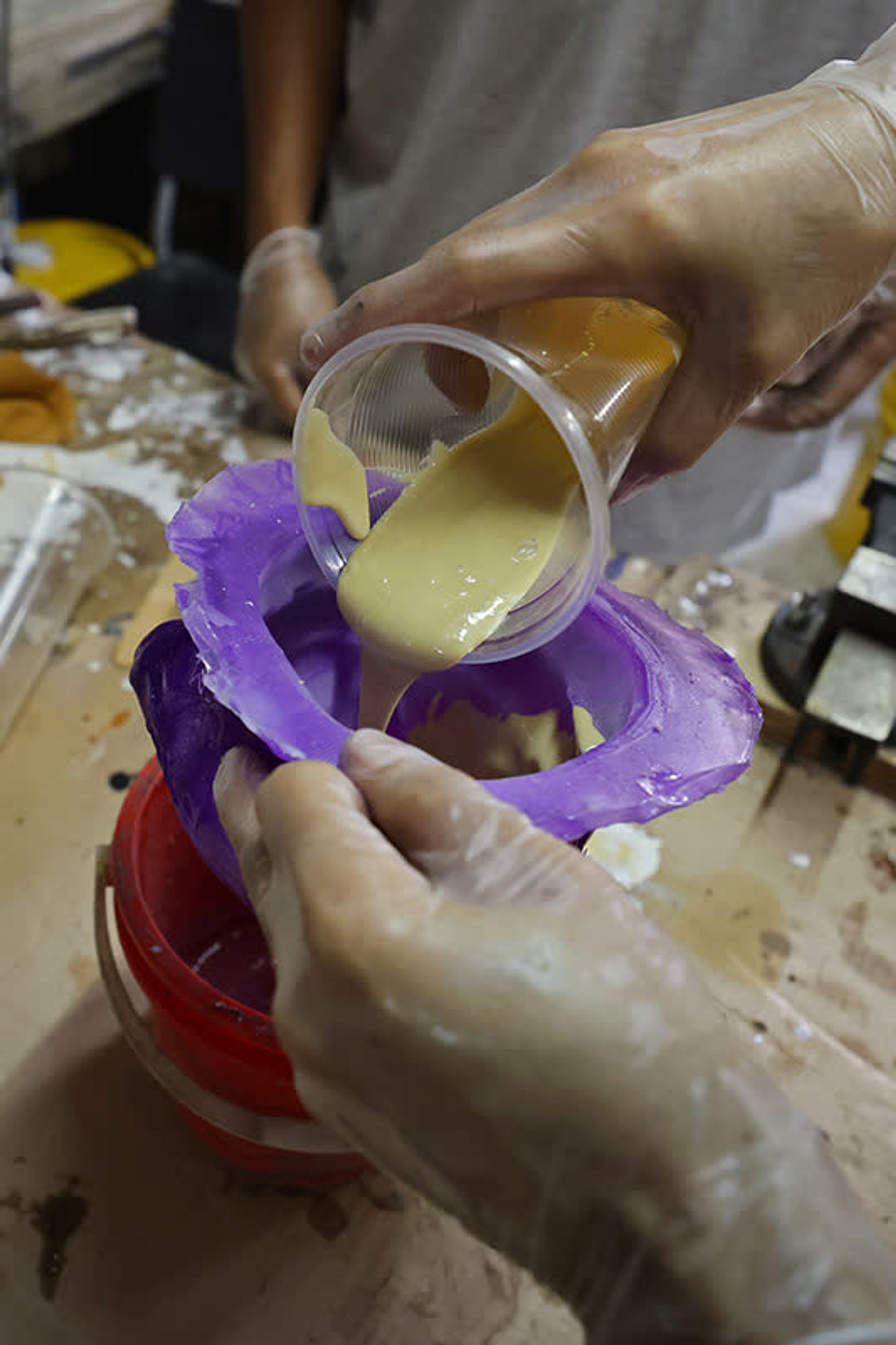 Mr Yeo pouring a rigid polyurethane foam mix into a mould to create a dog puppet’s head.