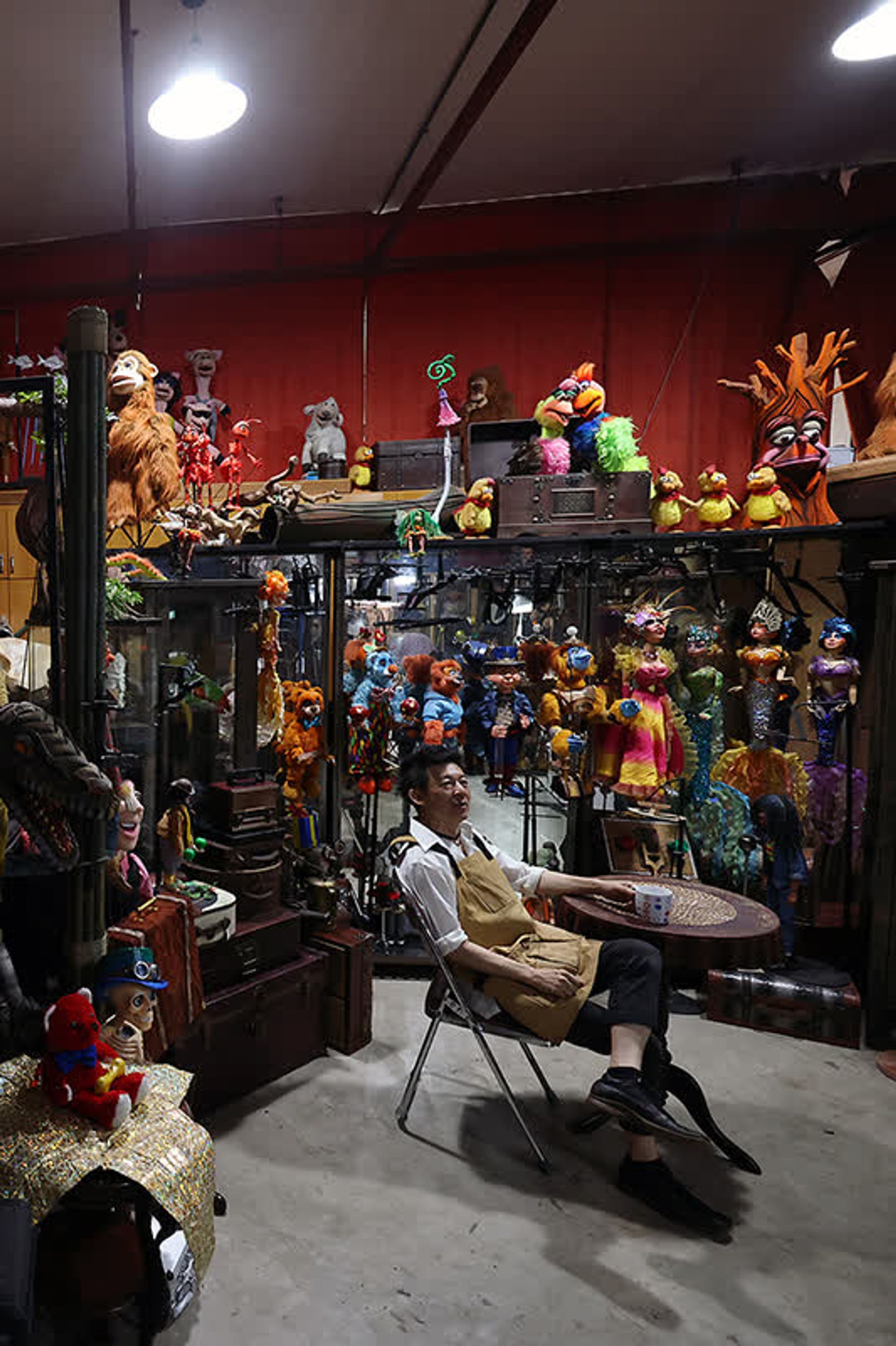 Mr Yeo looking at his puppets as he takes a break from work in his studio.