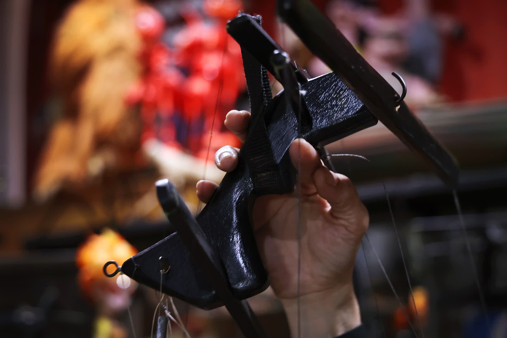 Mr Yeo holding a controller used to manipulate string puppets.